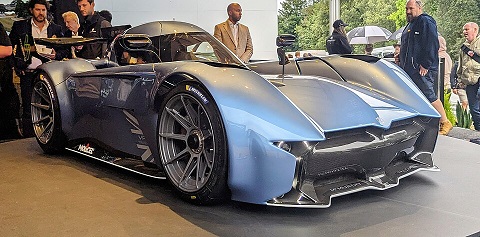 McMurtry Spéirling electric hypercar with compact body and large rear wing, shown in a static outdoor setting.