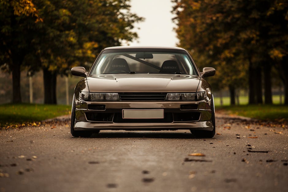 Front view of a tuned Nissan Silvia S14 with an aggressive body kit, lowered stance, and custom headlights, highlighting its JDM performance styling