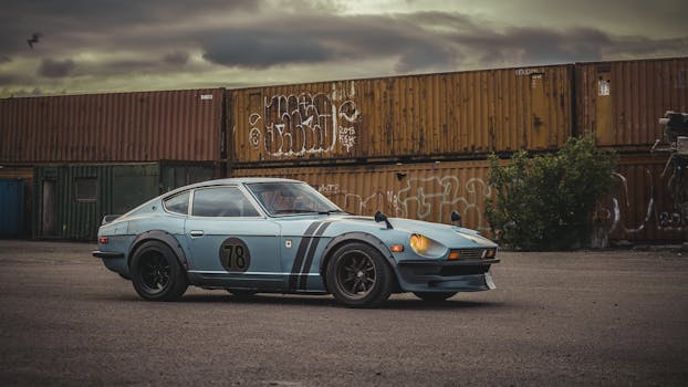 A classic Datsun sports car parked near cargo containers under a cloudy sky in Copenhagen.