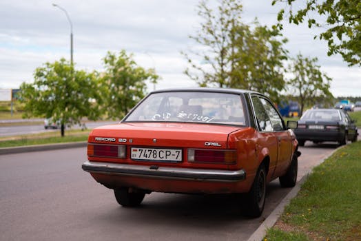 Rear view of a vintage orange Opel car parked on a suburban street, capturing classic automotive design.