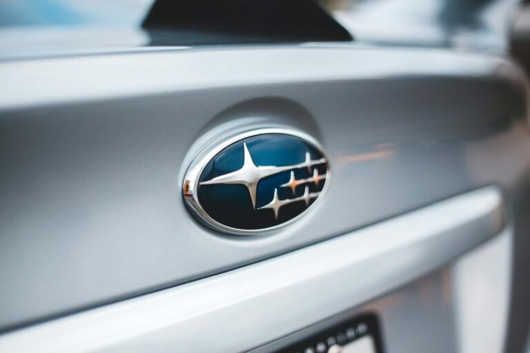 Detailed image of a Subaru emblem on a silver car, showcasing design and branding.