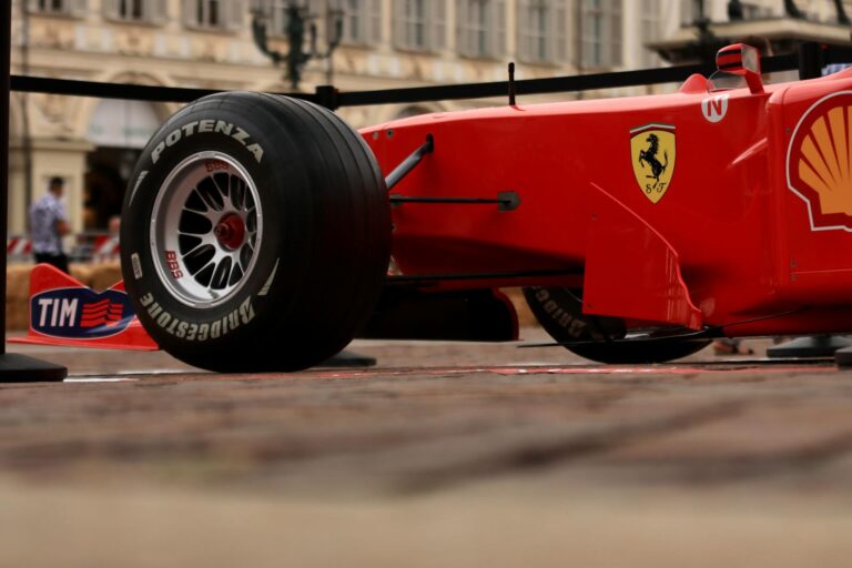 Close-up shot of a red Formula 1 racing car with visible brand logos and Bridgestone tire.