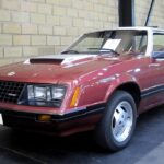 Red 1980 Ford Mustang parked inside a garage