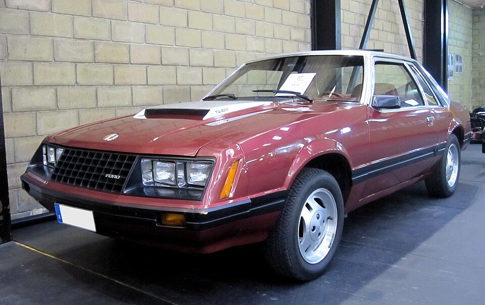 Red 1980 Ford Mustang parked inside a garage