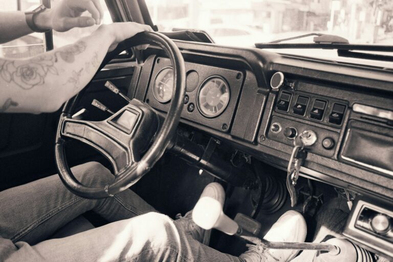 a person sitting in a car with a steering wheel