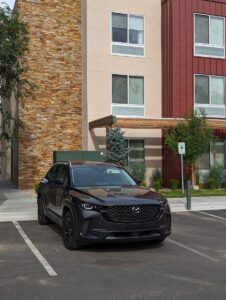A sleek black Mazda SUV parked in front of modern urban architecture in Sun Valley, Idaho. Best Suv for the money