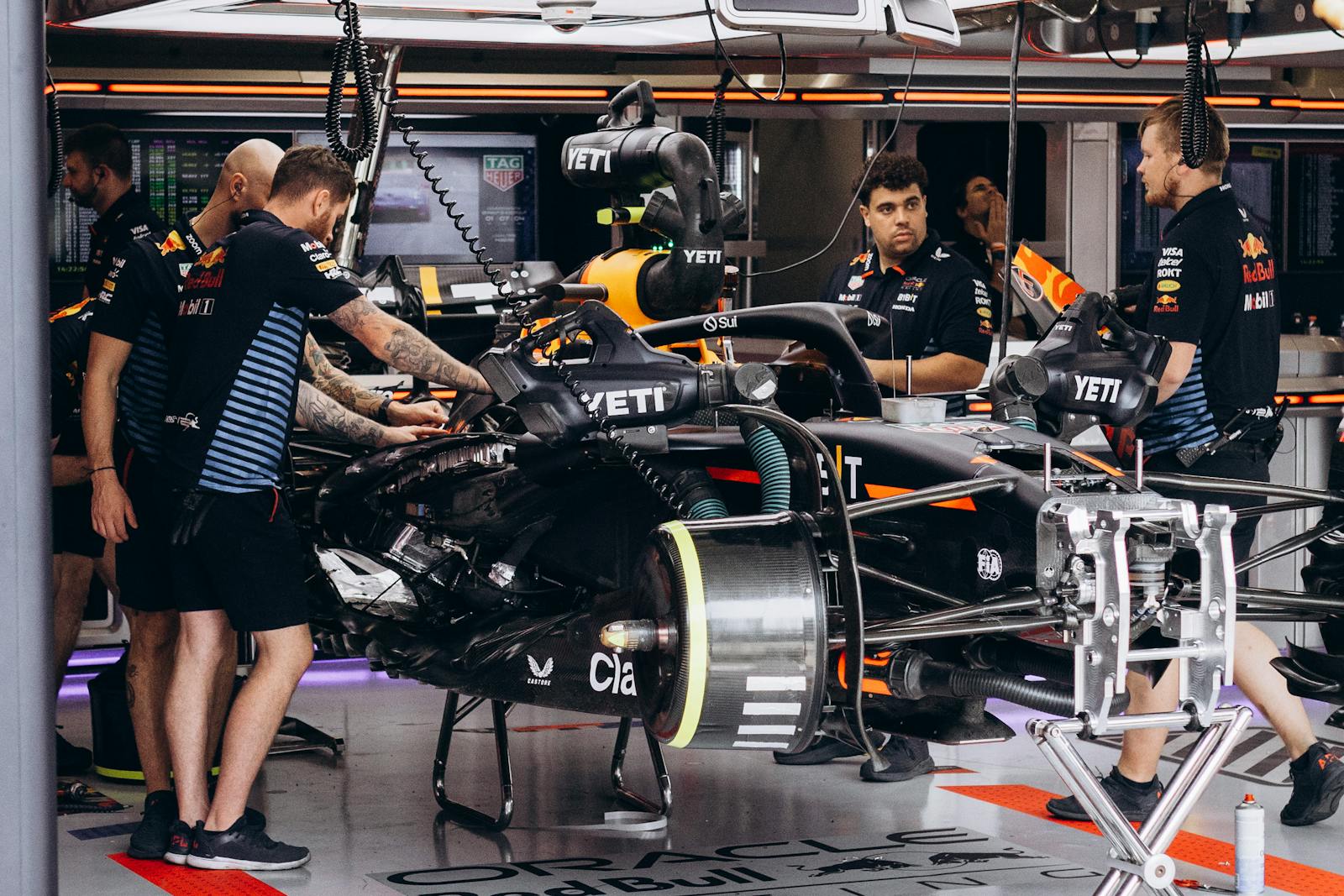 Formula 1 team mechanics work on a race car in the garage, preparing for the competition.