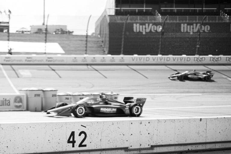 A black and white photo of a race car on a track