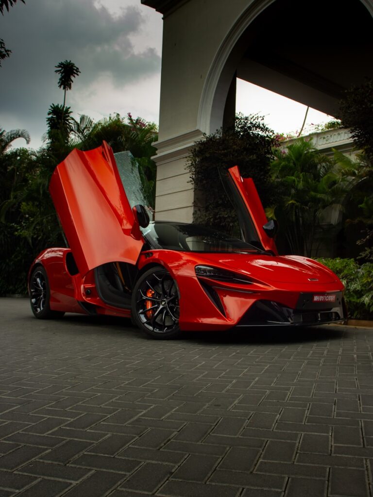 A bright red mclaren shows off its doors.