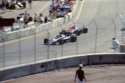 Nelson Piquet leading Ayrton Senna during the 1984 United States Grand Prix in Dallas, driving a Brabham-BMW on a historic F1 street circuit.
