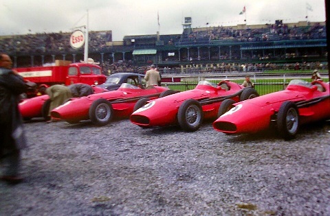 "Maserati 250F Formula 1 cars on the grid at the 1957 British Grand Prix, driven by legends like Fangio and Behra"