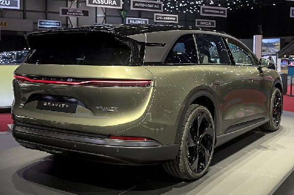 Lucid Gravity SUV rear view at auto show, highlighting taillights and aerodynamic design